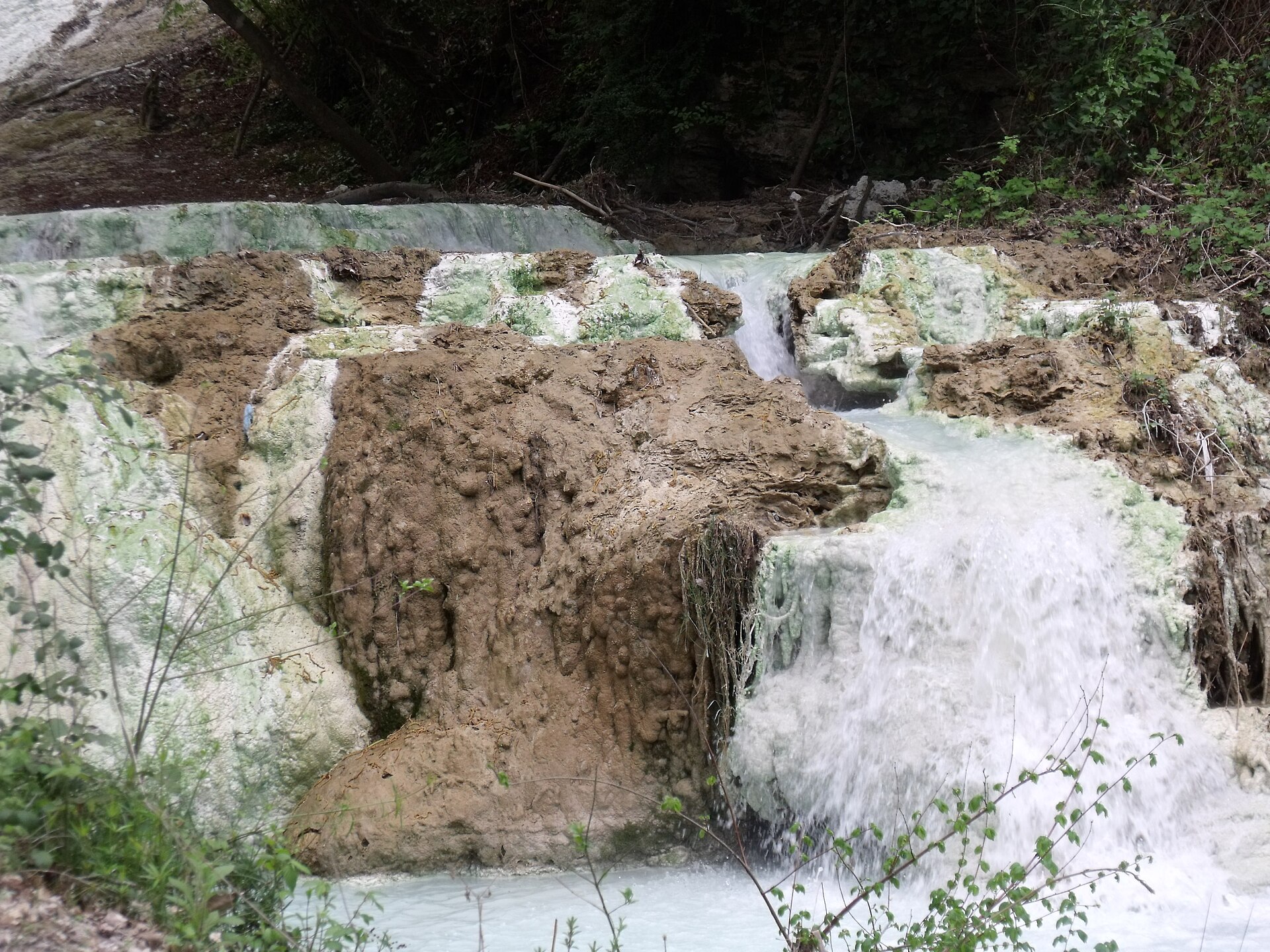 Hot water cascading over white limestone deposits in the Fosso Bianco stream at Bagni San Filippo