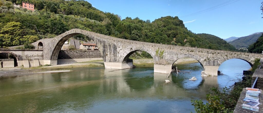 The humpbacked Ponte della Maddalena (Devil's Bridge) arching over the Serchio river at Borgo a Mozzano