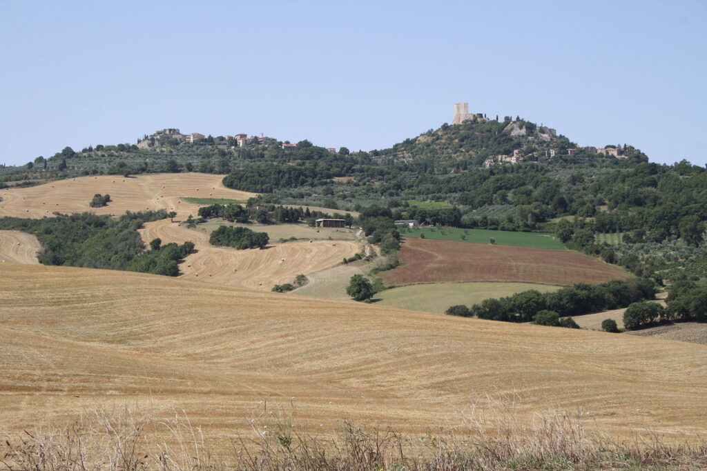 Harvested wheat fields below the hilltops of Castiglione d'Orcia and Rocca d'Orcia, seen from the Via Cassia