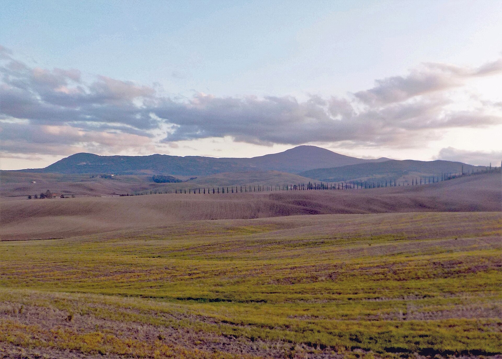 The volcanic cone of Monte Amiata rising beyond the golden fields of the Val d'Orcia