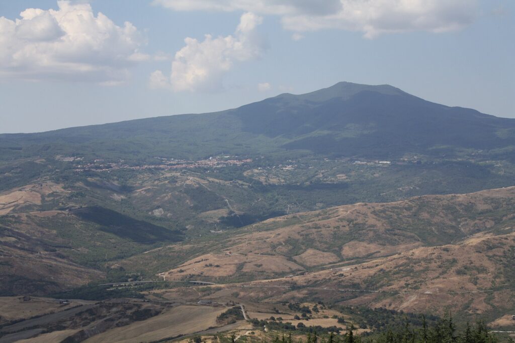 Monte Amiata seen from Radicofani across wooded hills and bare clay slopes