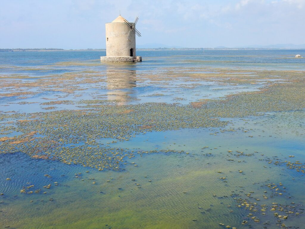 The old windmill standing in the shallow water of the Orbetello lagoon
