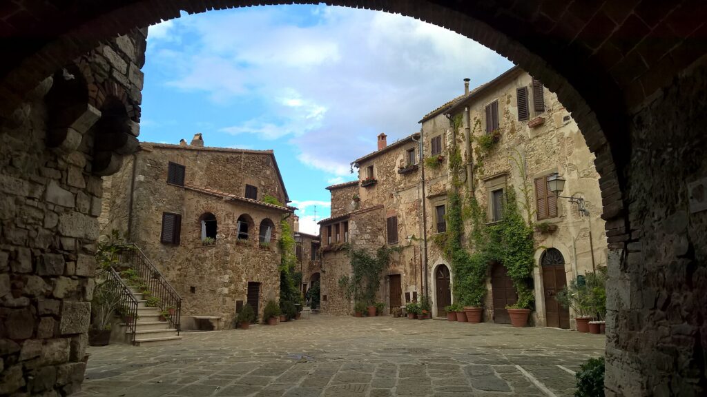 Piazza del Castello in Montemerano, seen through a stone archway