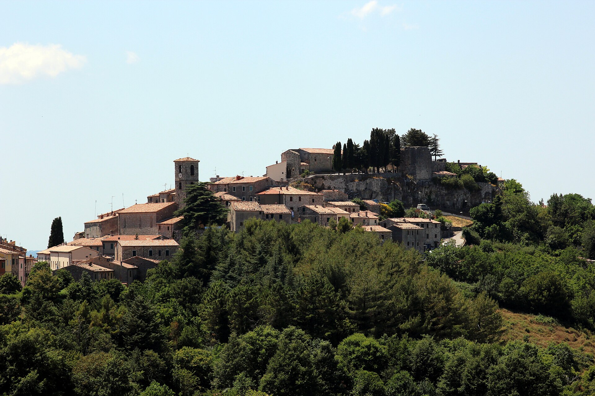 Semproniano's hilltop village and castle above green woods in southern Amiata