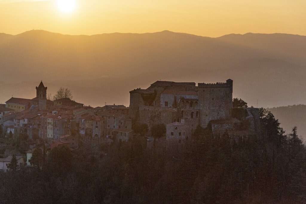 The Malaspina castle of Fosdinovo and its village at dusk