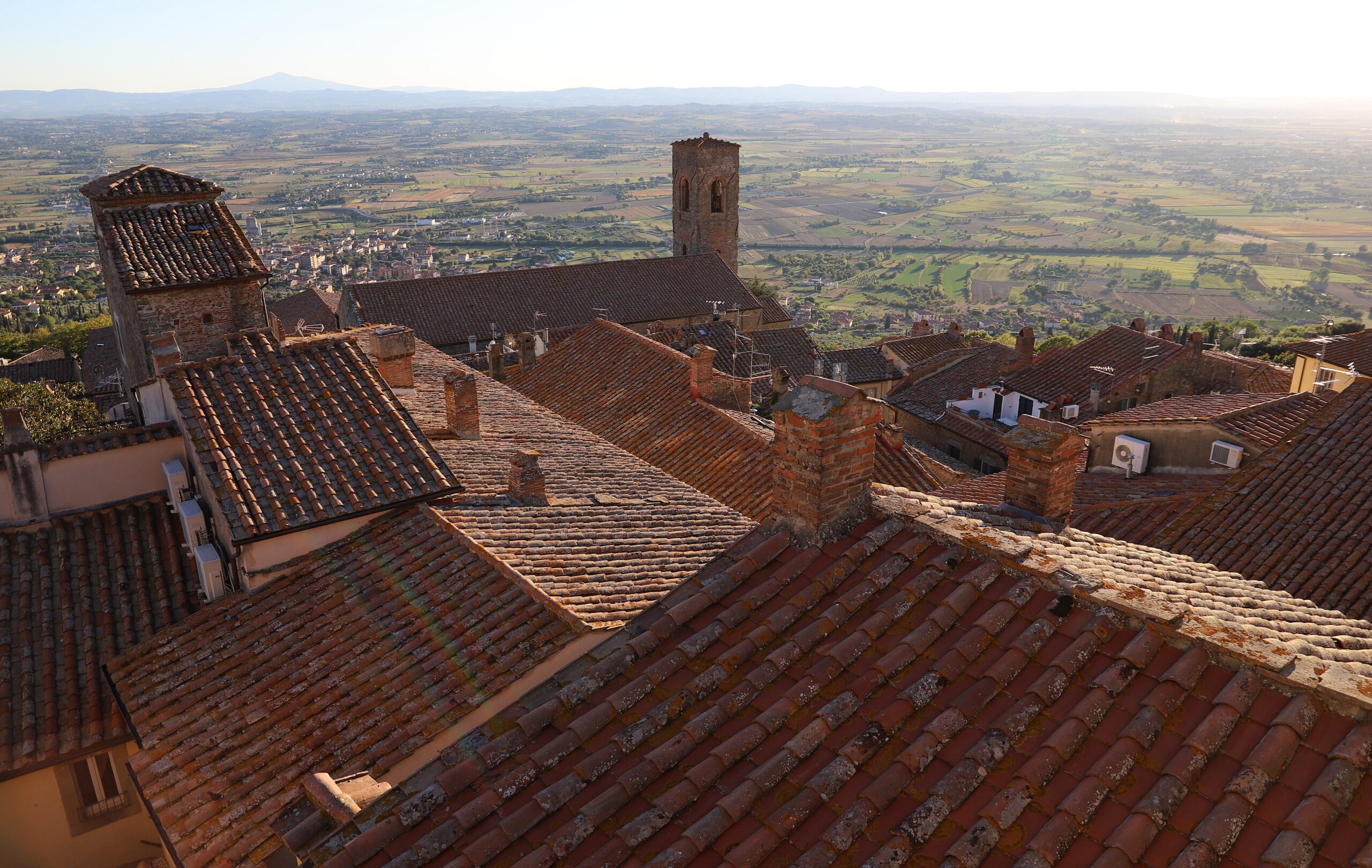 Cortona's terracotta rooftops with the Valdichiana beyond