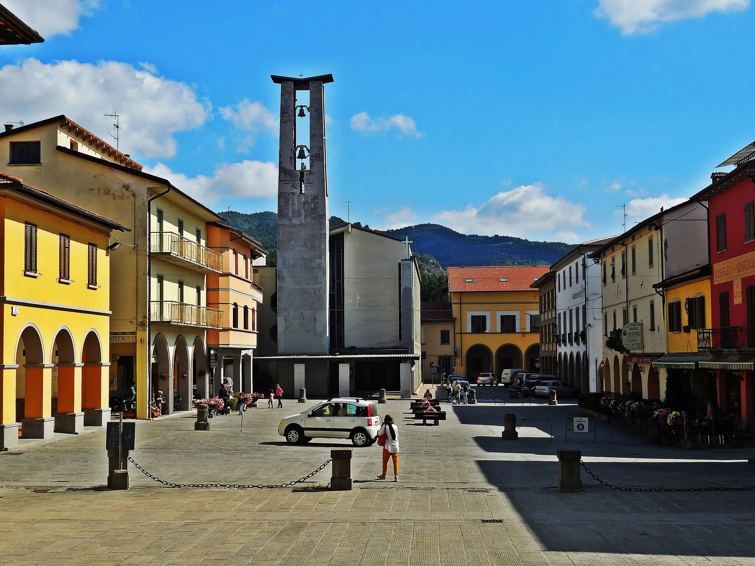 Piazza Don Casini in Firenzuola, the rebuilt town's main square with its modern bell tower and the Apennines beyond