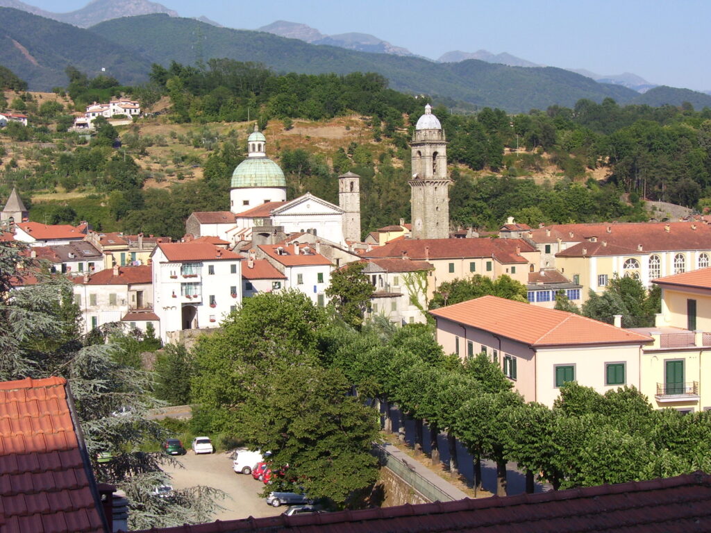 Pontremoli's rooftops and bell towers seen from above, with the Apennine foothills behind